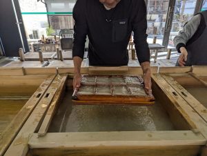 紙漉き体験をしている場面
