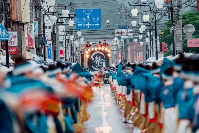 チーム祭屋のタペストリーと列に並ぶ踊り子たち